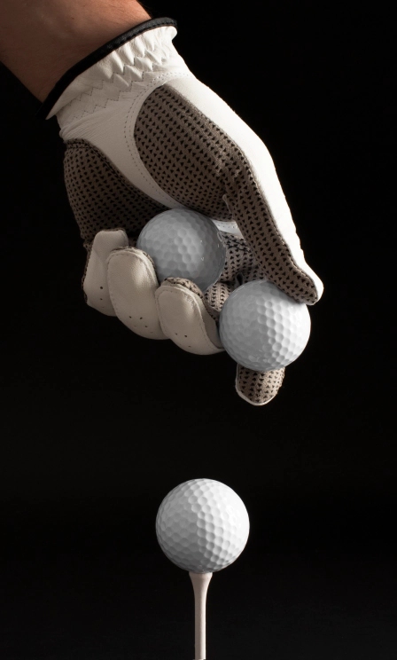 view hand with glove holding golf balls